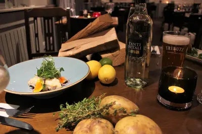 a table with a plate of food and a bottle of beer at The Pityme Inn in Wadebridge