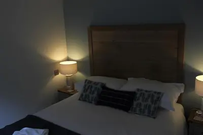 a bedroom with a bed with pillows and two lamps at The Pityme Inn in Wadebridge