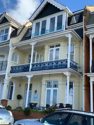 a large white house with a blue balcony at Lazy Waves in Newquay