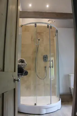 a shower with a glass door in a bathroom at Sky Cottage in Golant village near Fowey in Fowey