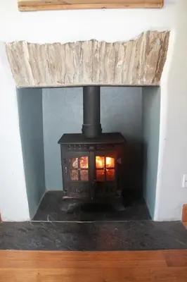 a fireplace with a stove in a room at Sky Cottage in Golant village near Fowey in Fowey