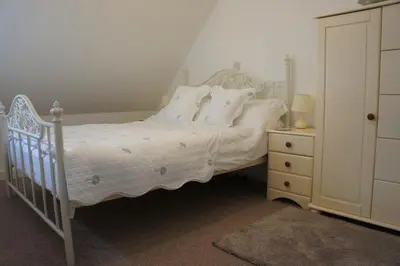 a bedroom with a bed with white sheets and pillows at The annex, Ruthvose in Saint Columb Major