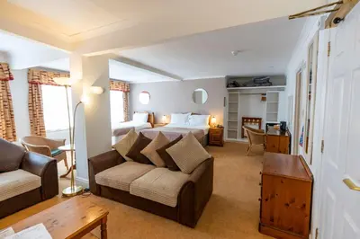 a bedroom with a bed and a couch in a room at Tyacks Hotel in Camborne