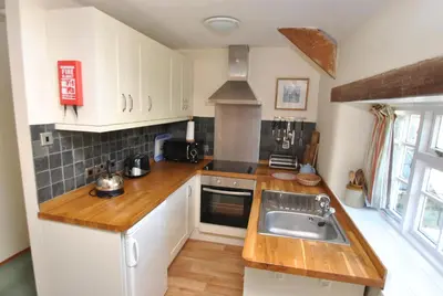 a kitchen with white cabinets and a sink at The Hayloft in Bude