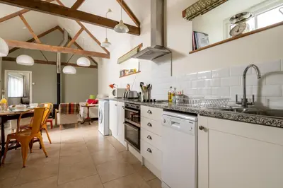 a kitchen with white appliances and a dining room at Lambriggan Court in Perranzabuloe