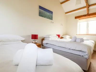 a bedroom with two beds and a window at Wheal Hart in Newlyn East