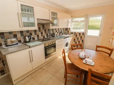 a kitchen with a wooden table and a kitchen with a stove and oven at The Shack in Mawgan Porth