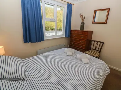 a bedroom with a bed with two towels on it at The Shack in Mawgan Porth