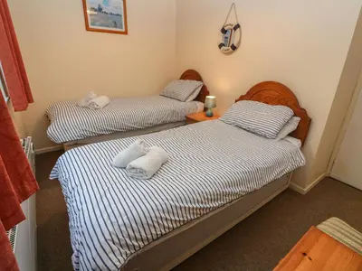 two twin beds in a room with towels on them at The Shack in Mawgan Porth