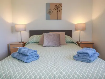 a bedroom with a bed with blue towels on it at The Station Flat in Newlyn East
