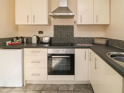 a kitchen with white cabinets and a stove top oven at 3 Rosecraddoc Lodge in Saint Cleer