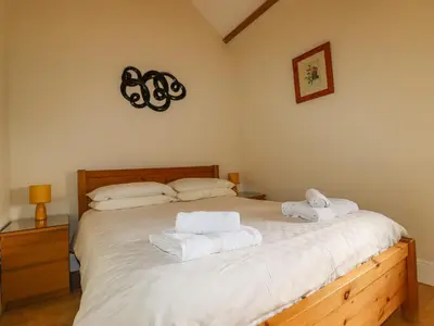 a bedroom with a bed with towels on it at Wheal Honey in Newlyn East