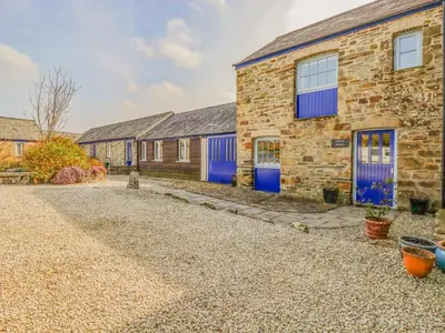 a stone house with blue doors and a gravel driveway at Wheal Honey in Newlyn East