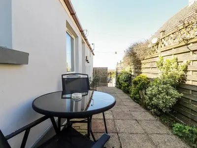 a table and chair on a patio outside a building at The Annexe, Laburnum in Bugle