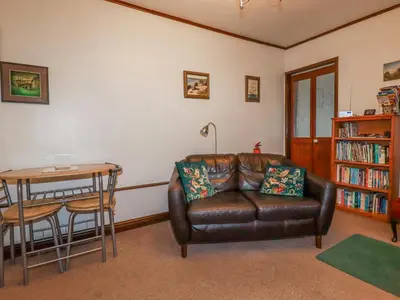 a living room with a leather couch and a table at The Annexe, Laburnum in Bugle