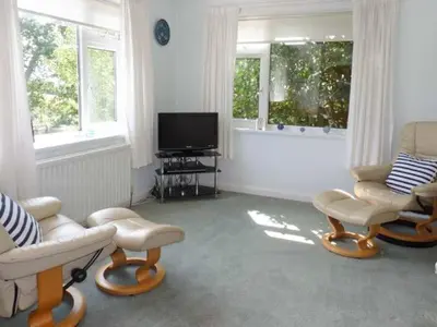 a living room with two chairs and a television at Joylands in Budock Water