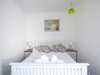 a white bed with pillows on top of it at Tidewood in Polzeath