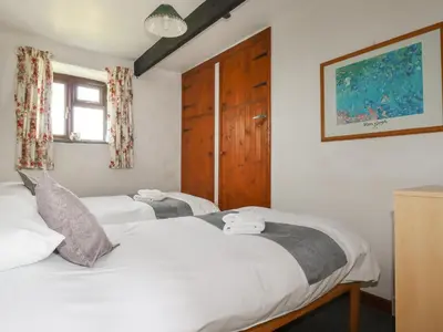 two twin beds in a room with a window at Kestrel Corner in Lanivet