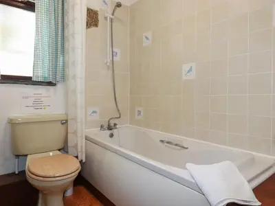 a bathroom with a white tub and a toilet at Kestrel Corner in Lanivet