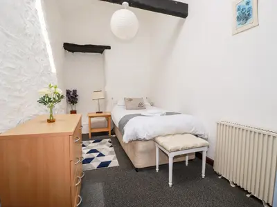 a bedroom with a bed and a dresser in it at Ravens Croft in Lanivet