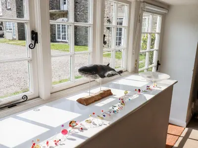 a bird on a counter in front of a window at Slate Cottage in Helland