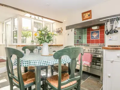 a kitchen with a table and chairs and a kitchen with a stove at The Watch Below in Polruan