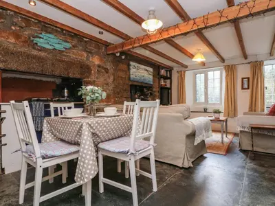 a living room with a table and chairs at Tinners Cottage in Saint Cleer