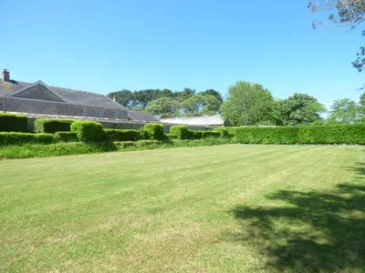 a large grass field with a house in the background at The Bullshed in Saint Erth