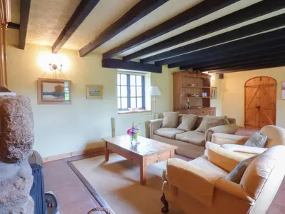 a living room with couches and a table at Old Winery Cottage in Golant