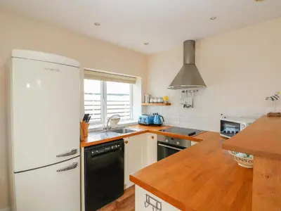 a kitchen with a white refrigerator and a sink at Bolenowe in Polzeath