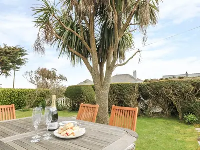 a table with a bottle of wine and a plate of food at Bolenowe in Polzeath