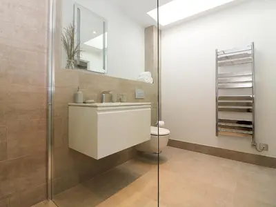 a bathroom with a toilet and a sink and a mirror at Pig House, Boskensoe Barns in Helford Passage