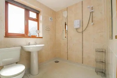 a bathroom with a shower and a toilet and a sink at Silverwell Forge in Chacewater