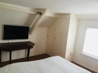 a bedroom with a bed and a television on the wall at Drang house all rooms have stairs in Padstow