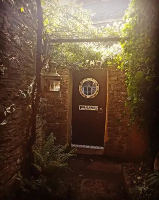 a black door with a sign on it at Polmarine in Polruan