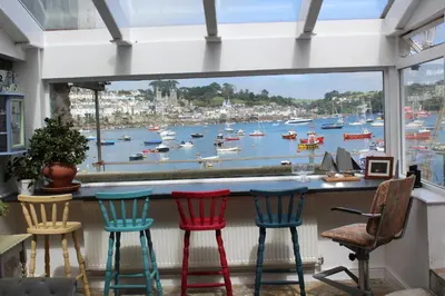 a bar with chairs and a view of a harbor at Polmarine in Polruan