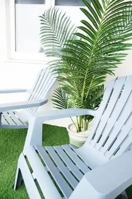 two white chairs sitting next to a potted plant at Ocean Views 3 in Newquay