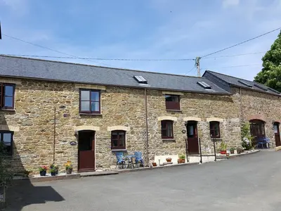 a stone building with doors and windows on a street at The Old Granary in Launceston
