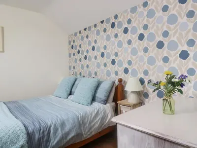 a bedroom with a bed and a vase of flowers at The Wagon House in Launceston