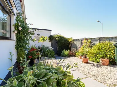a garden with plants and flowers on the side of a house at Jenny Wren in Par