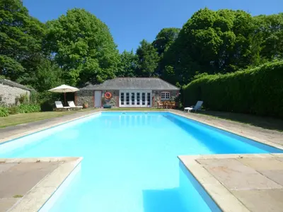 a large swimming pool in front of a house at The Granary in Saint Erth