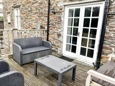 a chair and a coffee table on a patio at Tower House in Boscastle
