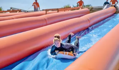 a young girl riding on a water slide at a water park at Atlantic Reach Resort in Newquay