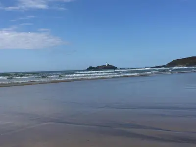 an empty beach with waves in the ocean at Gwithian, Sea Dream Beach Chalet in Gwithian