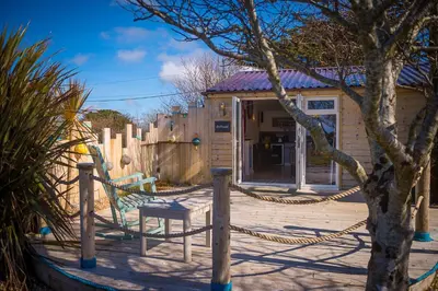a house with a rope fence and a playground at Driftwood in Bude