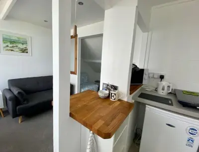 a kitchen with a table and a couch in a room at Coast Accommodation in St Ives