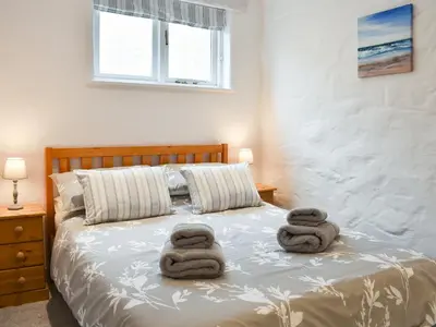 a bedroom with two towels on a bed at Willow - 31287 in Porthtowan