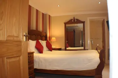 a bedroom with a large bed and a large mirror at Rose in Vale Country House Hotel in St. Agnes