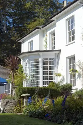 a white house with a large window at Penmere Manor Hotel in Falmouth