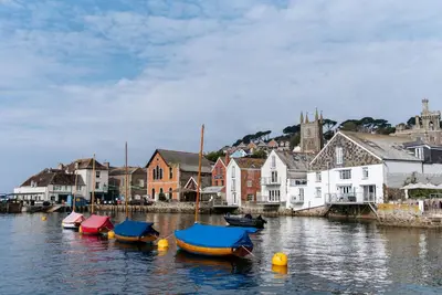 a group of boats in a body of water with houses at The Old Quay House Hotel in Fowey
